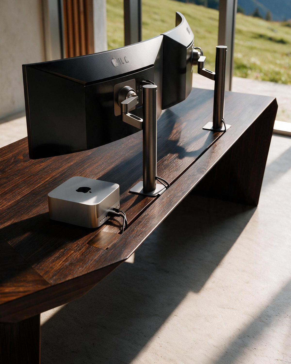 EDELHOLZ ArcPURE Schreibtisch in Smoked Amber, Nahaufnahme der Tischplatte mit Monitorarmen, Mac Studio und integriertem Kabeldurchlass [finish:smoked-amber]