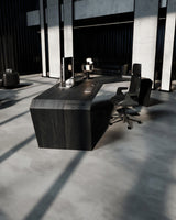 EDELHOLZ ArcPURE Schreibtisch in Midnight Noir, Seitenansicht des ArcPURE Eckschreibtischs mit Monitor, Tischleuchte und Bürostuhl vor bodentiefen Fenstern [finish:midnight-noir]