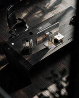EDELHOLZ DeskPRO Schreibtisch in Midnight Noir, Vogelperspektive auf die Tischplatte mit Monitor, Tastatur, Tischleuchte und Bürostuhl [finish:midnight-noir]