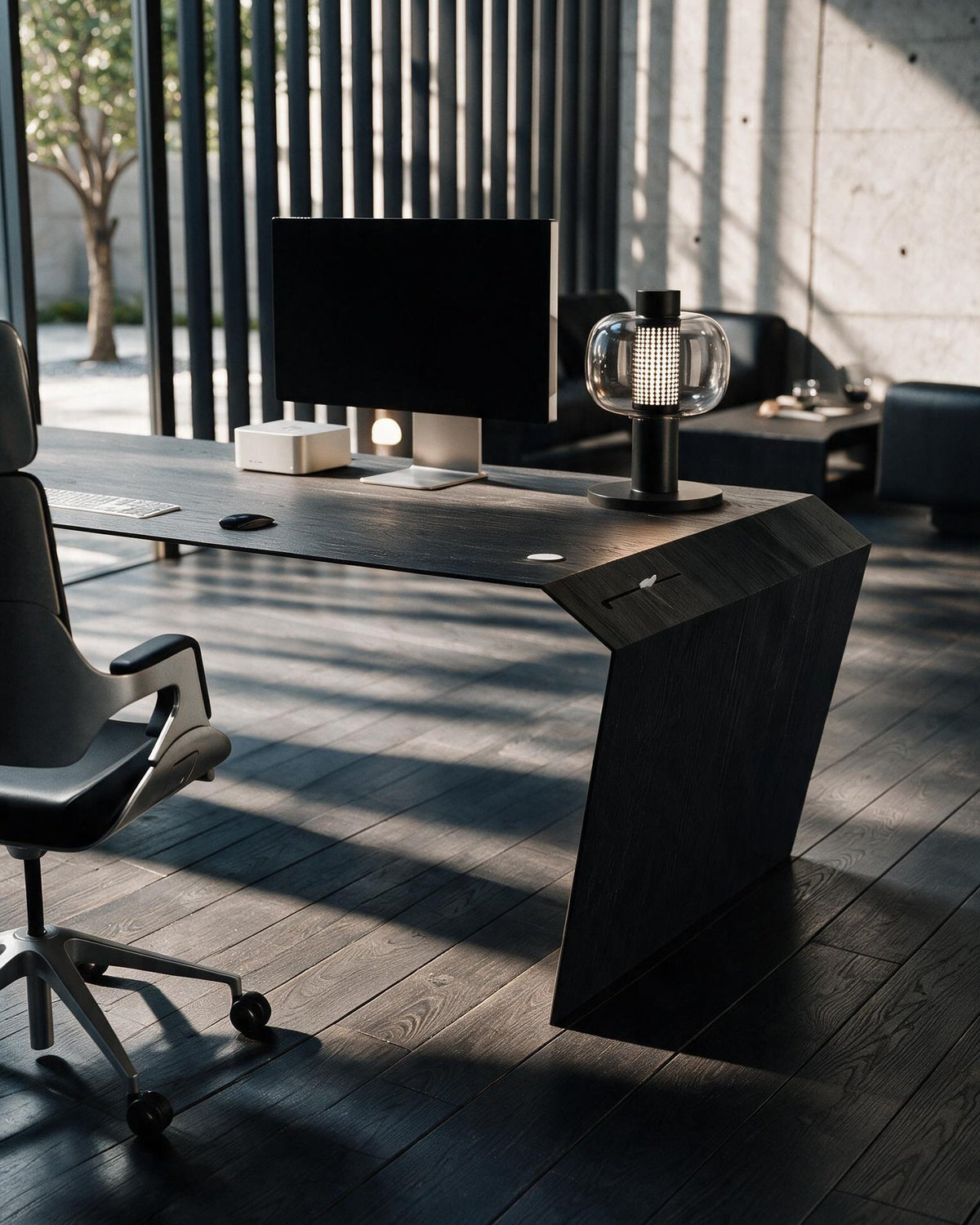 EDELHOLZ DeskPURE Schreibtisch in Midnight Noir, Raumansicht mit Bürostuhl, Monitor und Tischleuchte vor bodentiefen Fenstern [finish:midnight-noir]