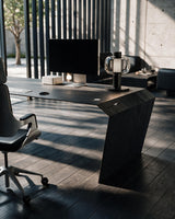 EDELHOLZ DeskPURE Schreibtisch in Midnight Noir, Raumansicht mit Bürostuhl, Monitor und Tischleuchte vor bodentiefen Fenstern [finish:midnight-noir]